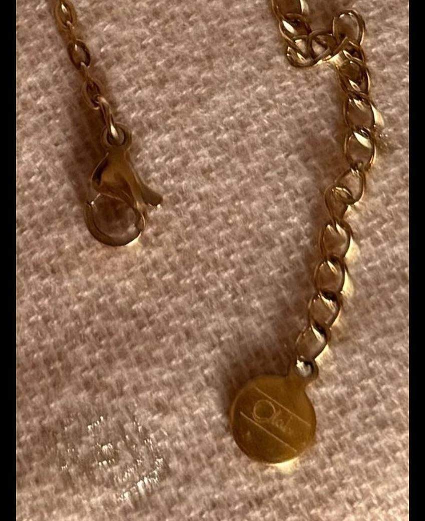 Bijoux or et acier disposés sur fond noir chaud