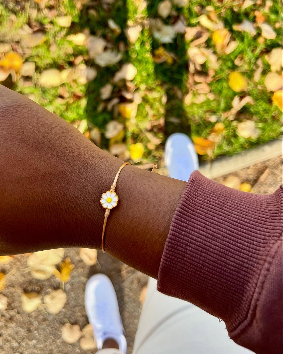 Poignet portant un bracelet Olah, fleurs en extérieur
