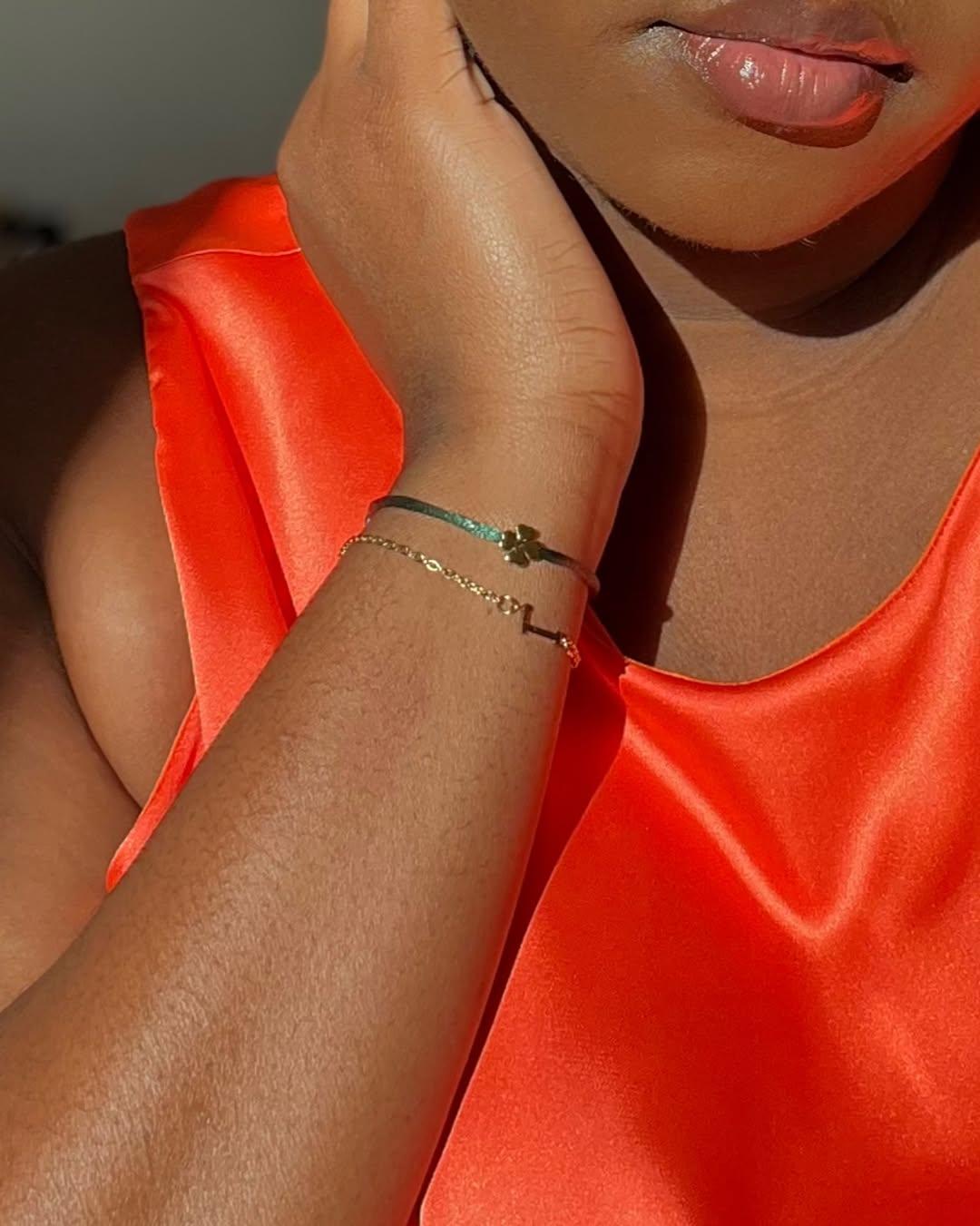 Bracelet trèfle doré porté au poignet