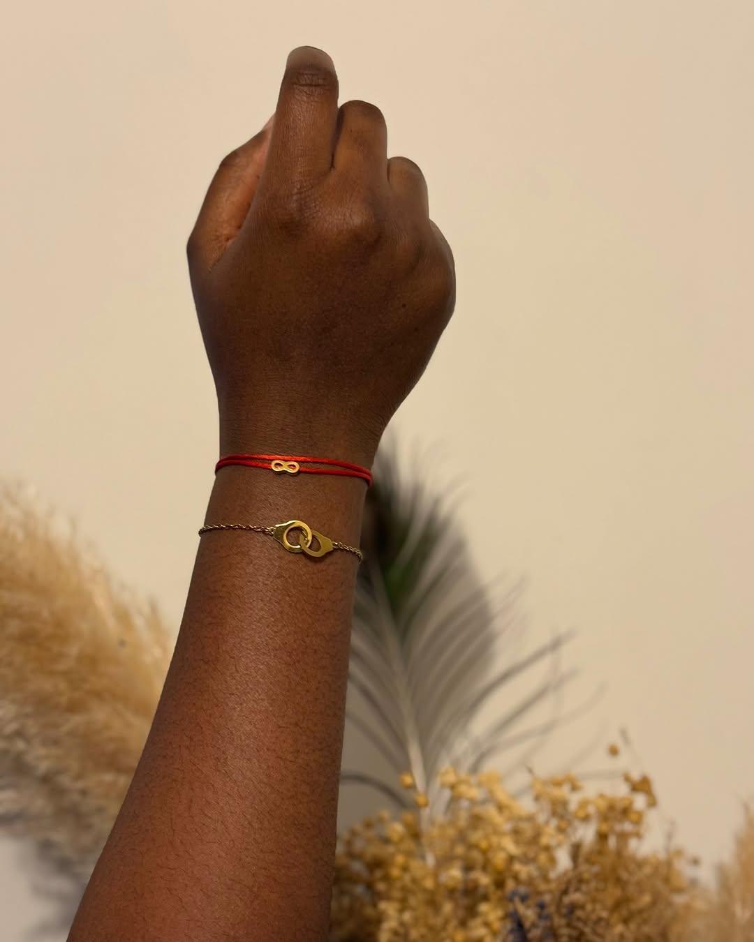 Accumulation de bracelets menotte et infini au poignet